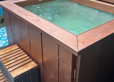 Charming outdoor hot tub at Plas Courtyard Spa in Llanbedr, Wales, GB offering a serene wellness experience.