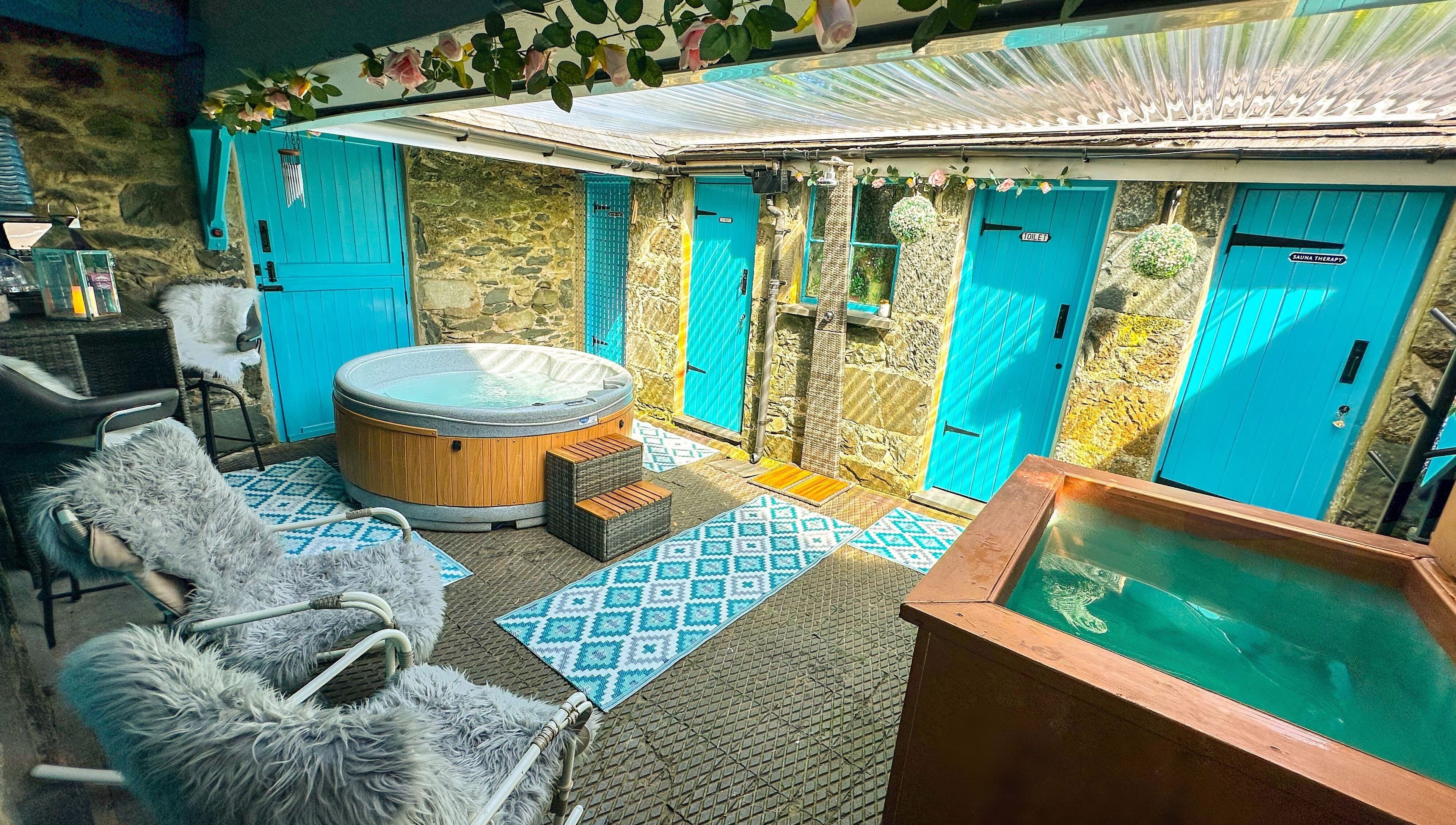 Luxury hot tub area at Plas Courtyard Spa, Llanbedr, Wales, GB with vibrant decor and natural light.