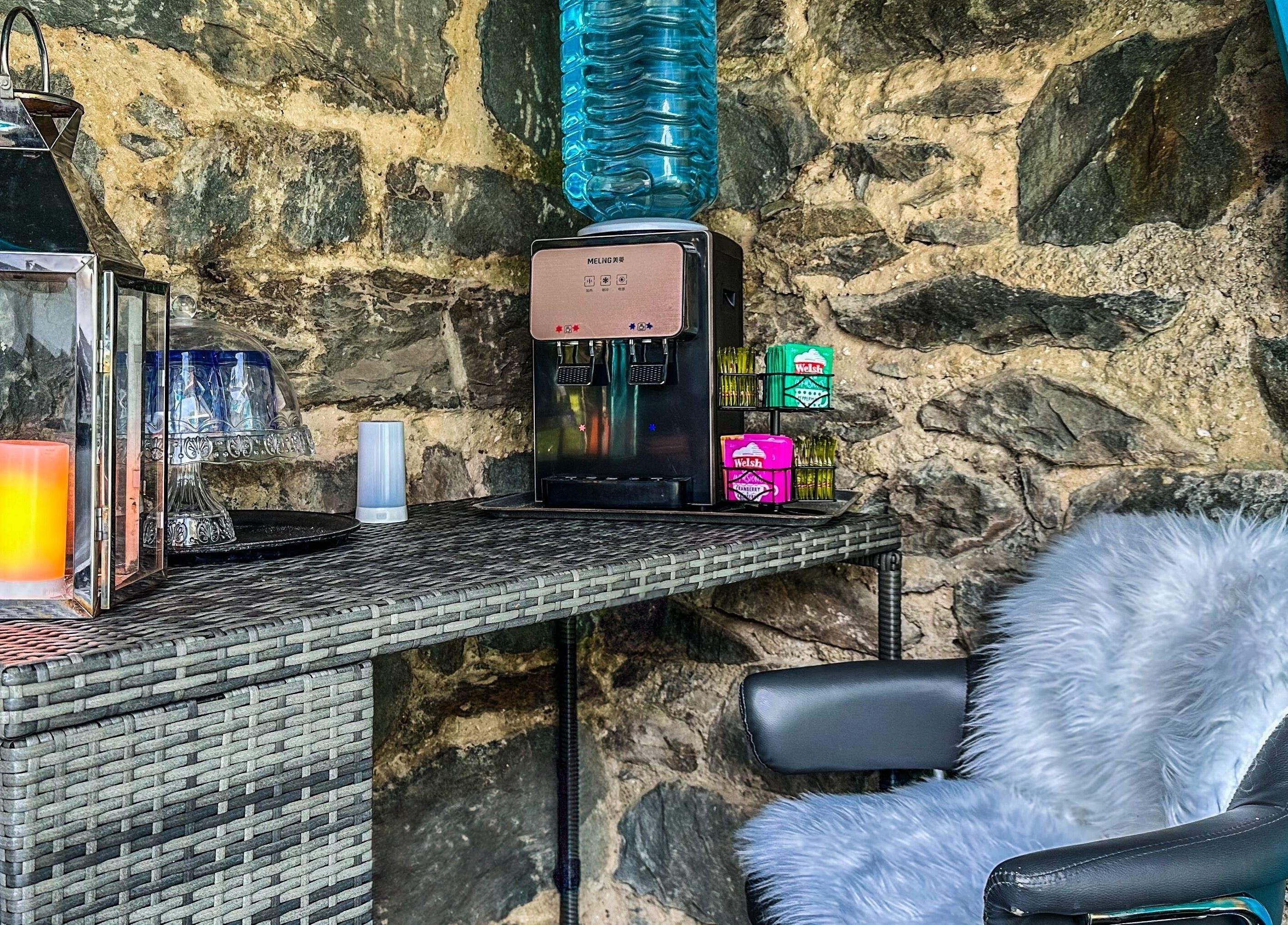 Quaint relaxation corner at Plas Courtyard Spa, Llanbedr, Wales, GB, featuring rustic stone wall and modern comforts.