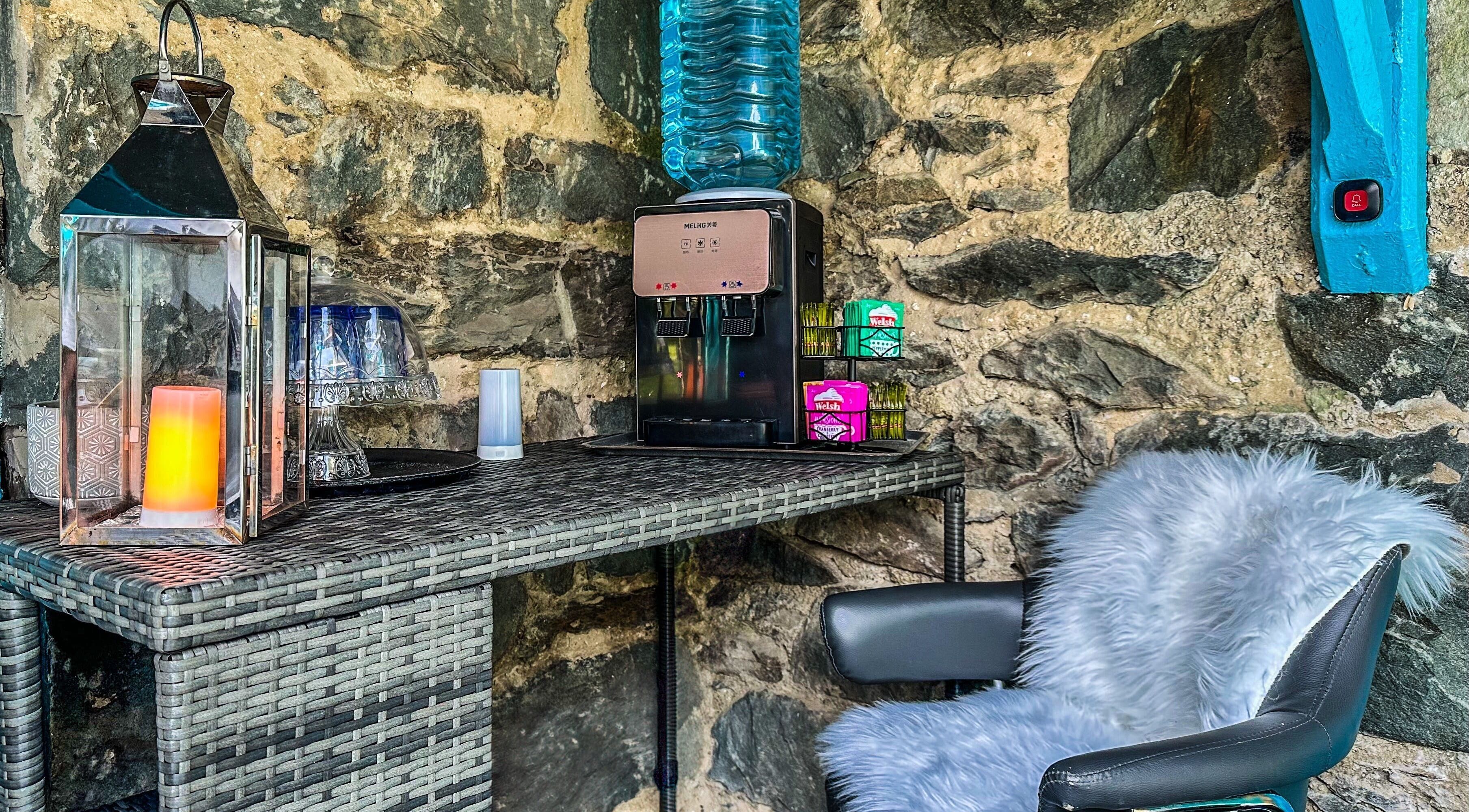 Quaint relaxation corner at Plas Courtyard Spa, Llanbedr, Wales, GB, featuring rustic stone wall and modern comforts.