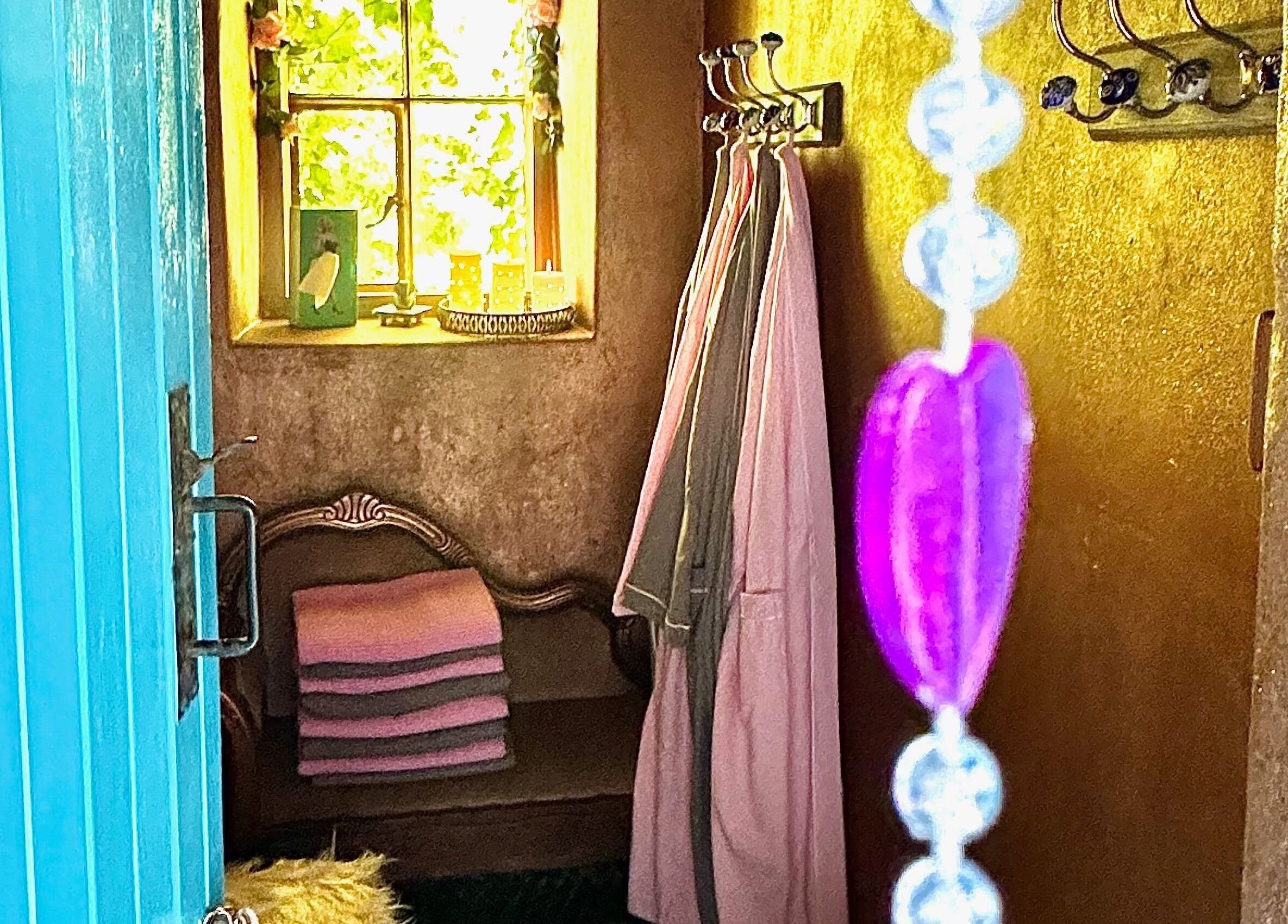 Cozy relaxation nook at Plas Courtyard Spa in Llanbedr, Wales, GB with robes and soft towels by a window.