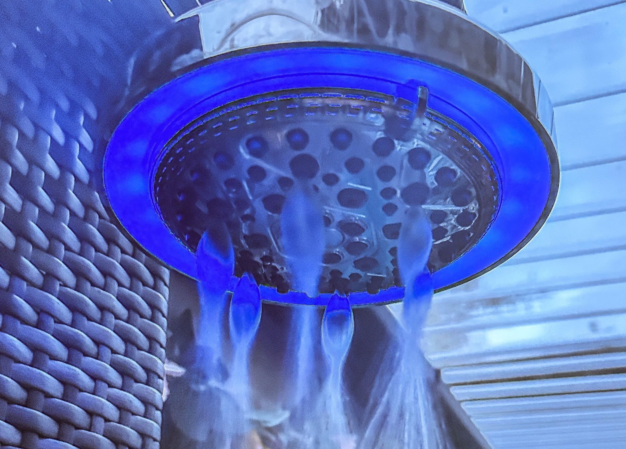 Illuminated blue showerhead at Plas Courtyard Spa, Llanbedr, Wales, GB offering a serene experience.