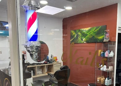 Interior do Davidson Barbeiro em Carcavelos, Lisboa, PT com cadeira de barbeiro e produtos em exposição.