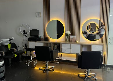 Interior moderno do Davidson Barbeiro em Carcavelos, Lisboa, PT, com cadeiras confortáveis e espelhos iluminados.