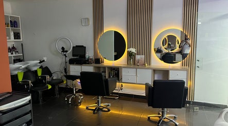 Interior moderno do Davidson Barbeiro em Carcavelos, Lisboa, PT, com cadeiras confortáveis e espelhos iluminados.