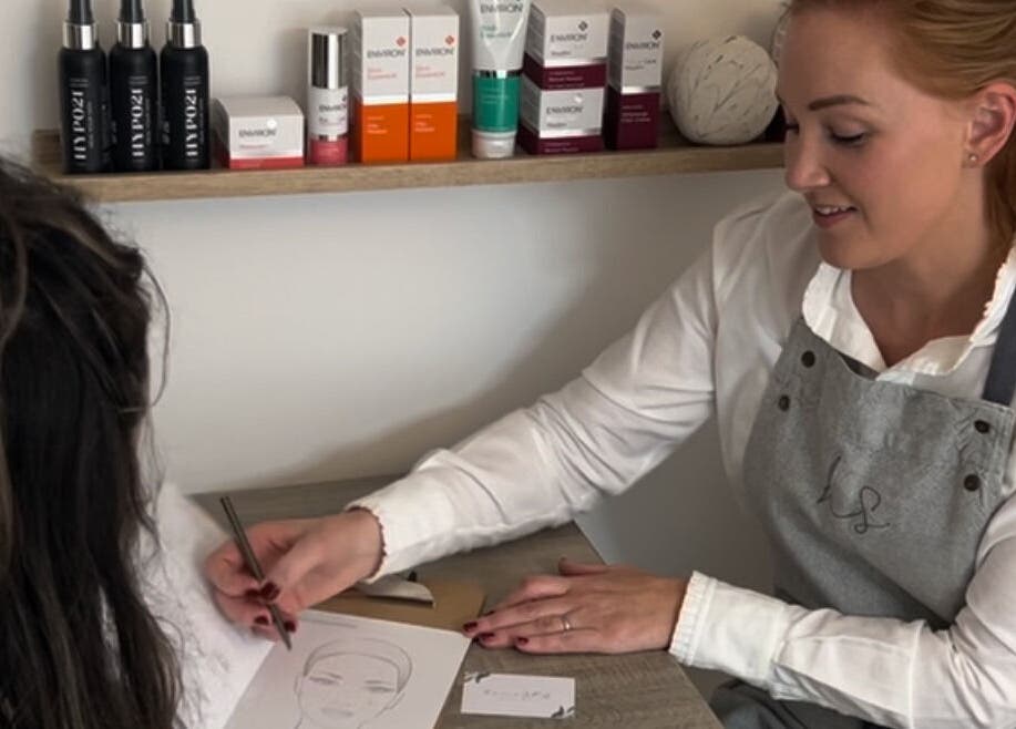 Makeup consultation in progress at Oak + Glow, Chaldon, England, GB with beauty products on display.