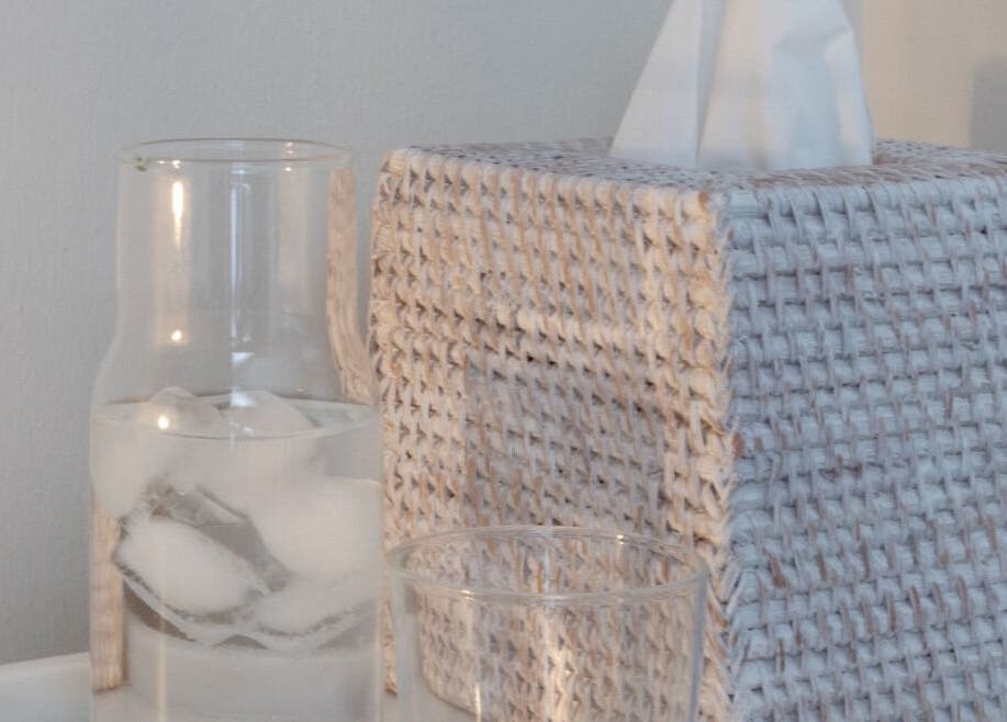 Glass carafe with ice water beside a textured tissue box at Oak + Glow, Chaldon, England, GB.