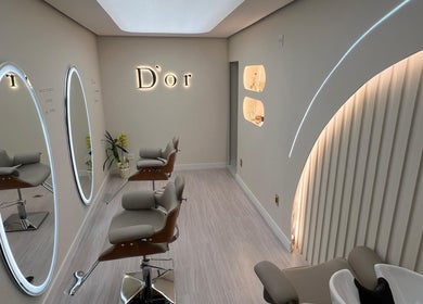 Sala de beleza elegante no Dor, São Paulo, SP, BR, com espelhos iluminados e cadeiras modernas.