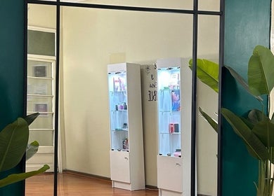 Interior de J.micropig en Ñuñoa, Región Metropolitana, CL con espejo, plantas y estantes iluminados.