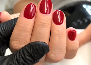 Polished red nails at The Nail Atelier Co. in Chelmsford, England, GB, showcasing expert manicure work.