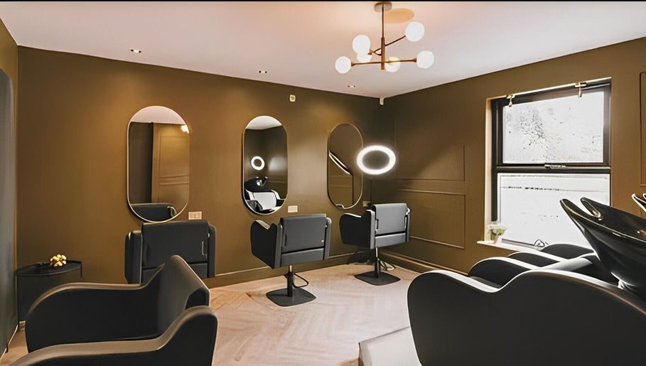 Modern salon interior at Hairbyreshi, Wolverhampton, England, GB, featuring stylish black chairs and mirrors.