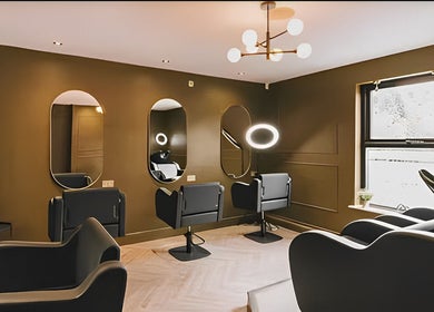 Modern salon interior at Hairbyreshi, Wolverhampton, England, GB, featuring stylish black chairs and mirrors.