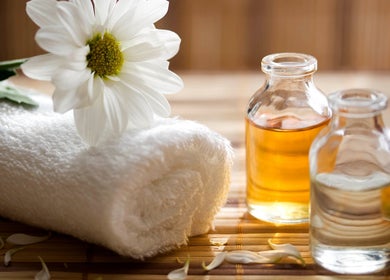 Tranquil setup at TL Foot Spa, Austin, Texas, US, featuring essential oils and towel with daisy.