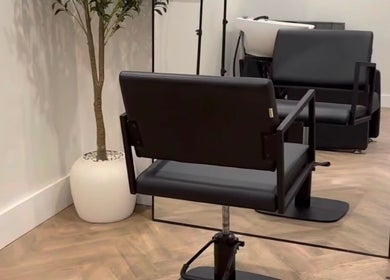 Modern salon interior with a styling chair at LUCY MARIE HAIR, Colchester, England, GB.