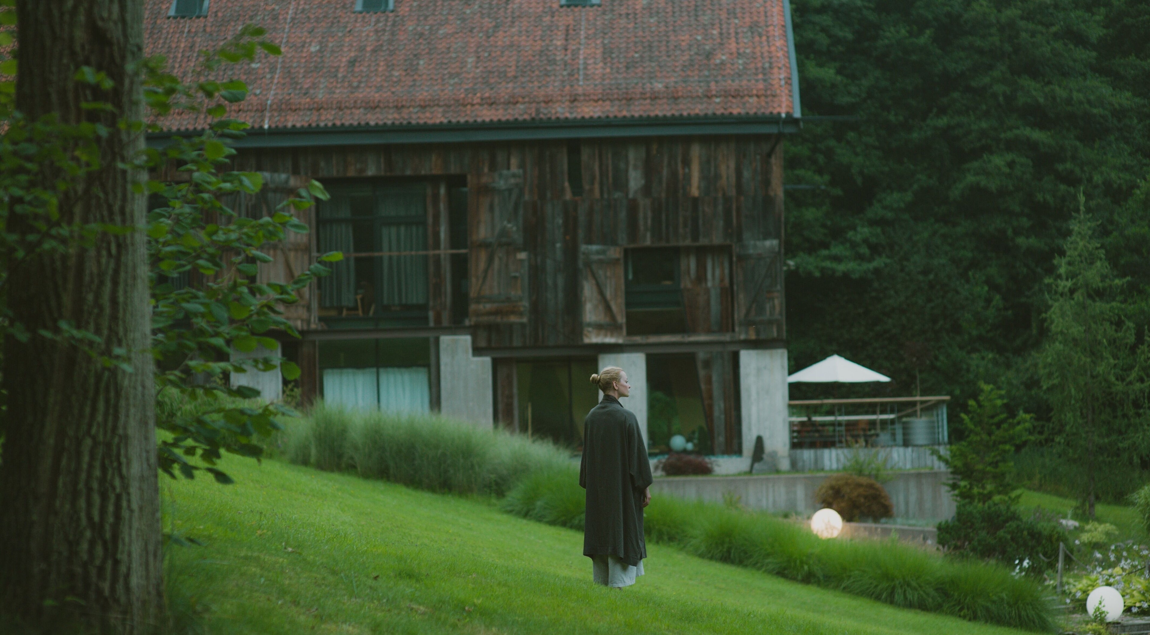 Malownicze otoczenie Sento Spa w Skowronach, Województwo Warmińsko-mazurskie, PL. Osoba odpoczywająca na trawie.