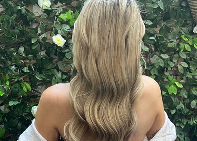 Blonde waves styled at Hairbychloebeatty in Sligo, County Sligo, IE, framed by lush greenery.