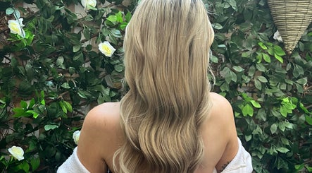 Blonde waves styled at Hairbychloebeatty in Sligo, County Sligo, IE, framed by lush greenery.