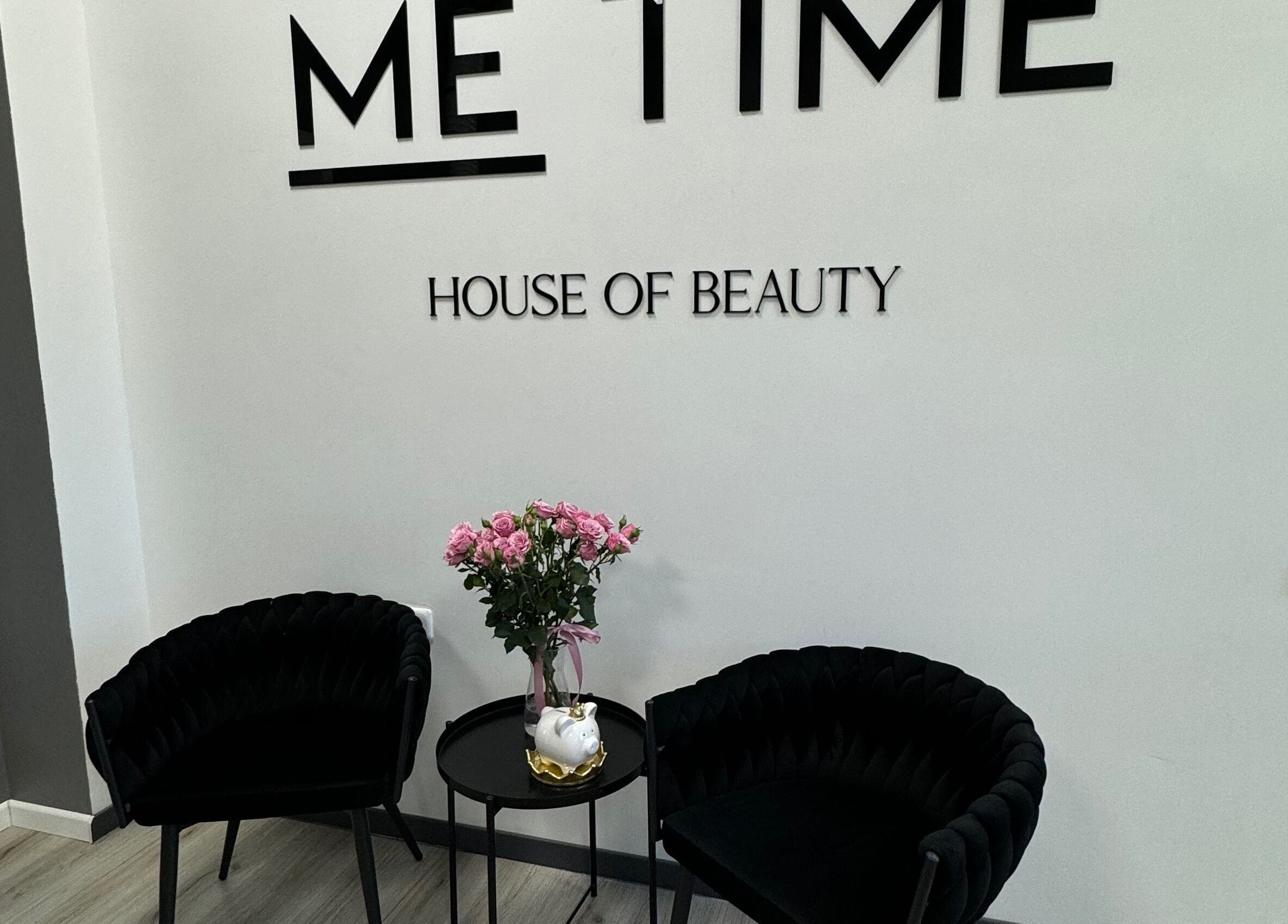 Elegant lounge area at ME TIME STUDIO in Jelgava, LV featuring black chairs and a floral arrangement.