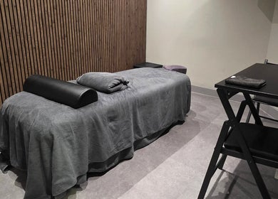 Rustige massageruimte in Tension Treat, Amsterdam, Noord-Holland, NL met comfortabele tafel en houten wand.