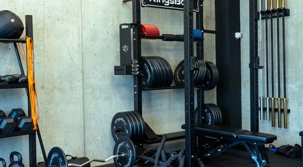 Krachttrainingsruimte bij Tension Treat, Amsterdam, Noord-Holland, NL met gewichten en barbells.