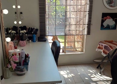 Bright, elegant corner of D's Hair Salon in Krugersdorp, Gauteng, ZA, featuring a stylish makeup desk and mirror.