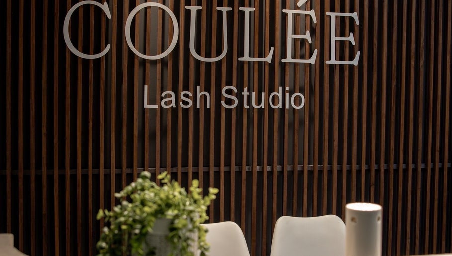 Entrance of Coulée Lash Studio in Sandton, Gauteng, ZA with sleek wooden decor.