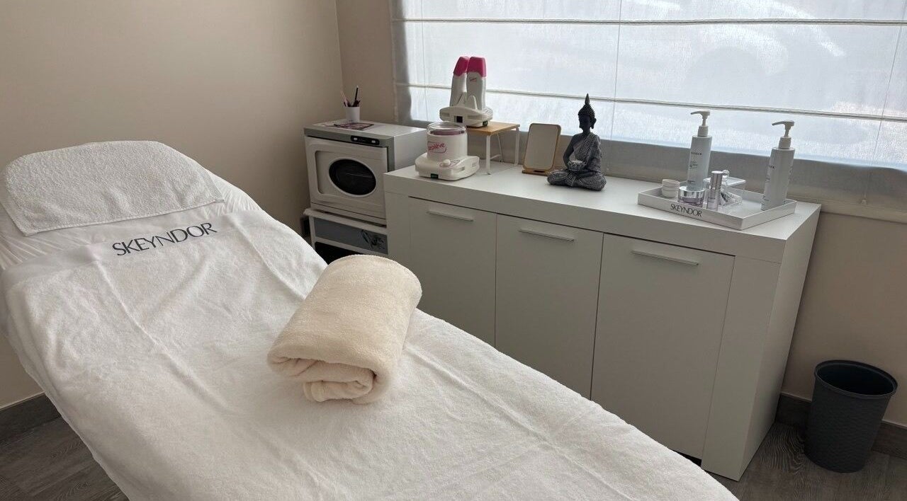 Sala de tratamiento en Clínica Estética AM, La Solana, Castilla-la Mancha, ES. Camilla con productos de belleza.