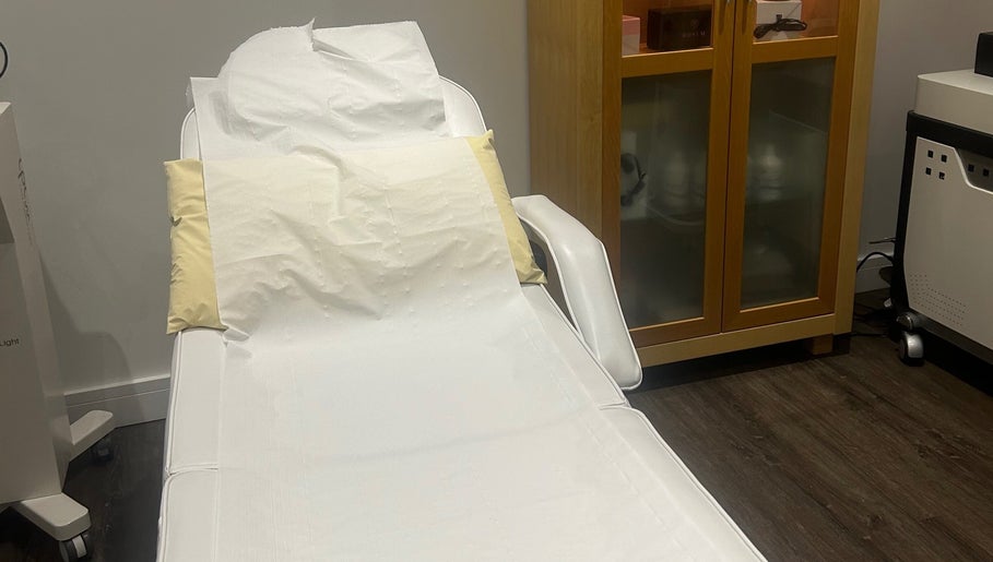 Comfortable treatment bed at Rosem Health Clinic, Nottingham, England, GB with wooden cabinet and machine.