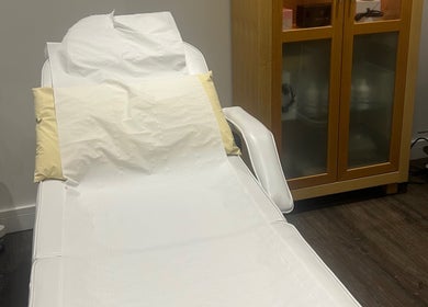 Comfortable treatment bed at Rosem Health Clinic, Nottingham, England, GB with wooden cabinet and machine.
