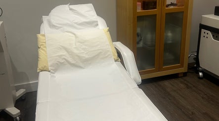Comfortable treatment bed at Rosem Health Clinic, Nottingham, England, GB with wooden cabinet and machine.