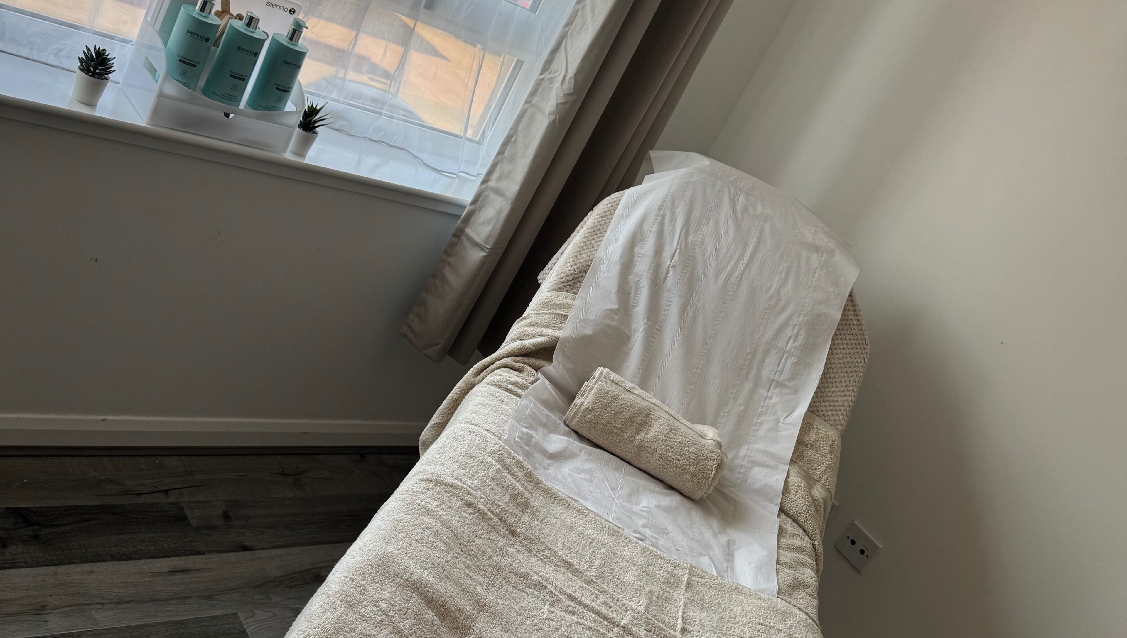 Relaxation room at Tame, Motherwell, Scotland, GB with a comfy massage table and skincare products.