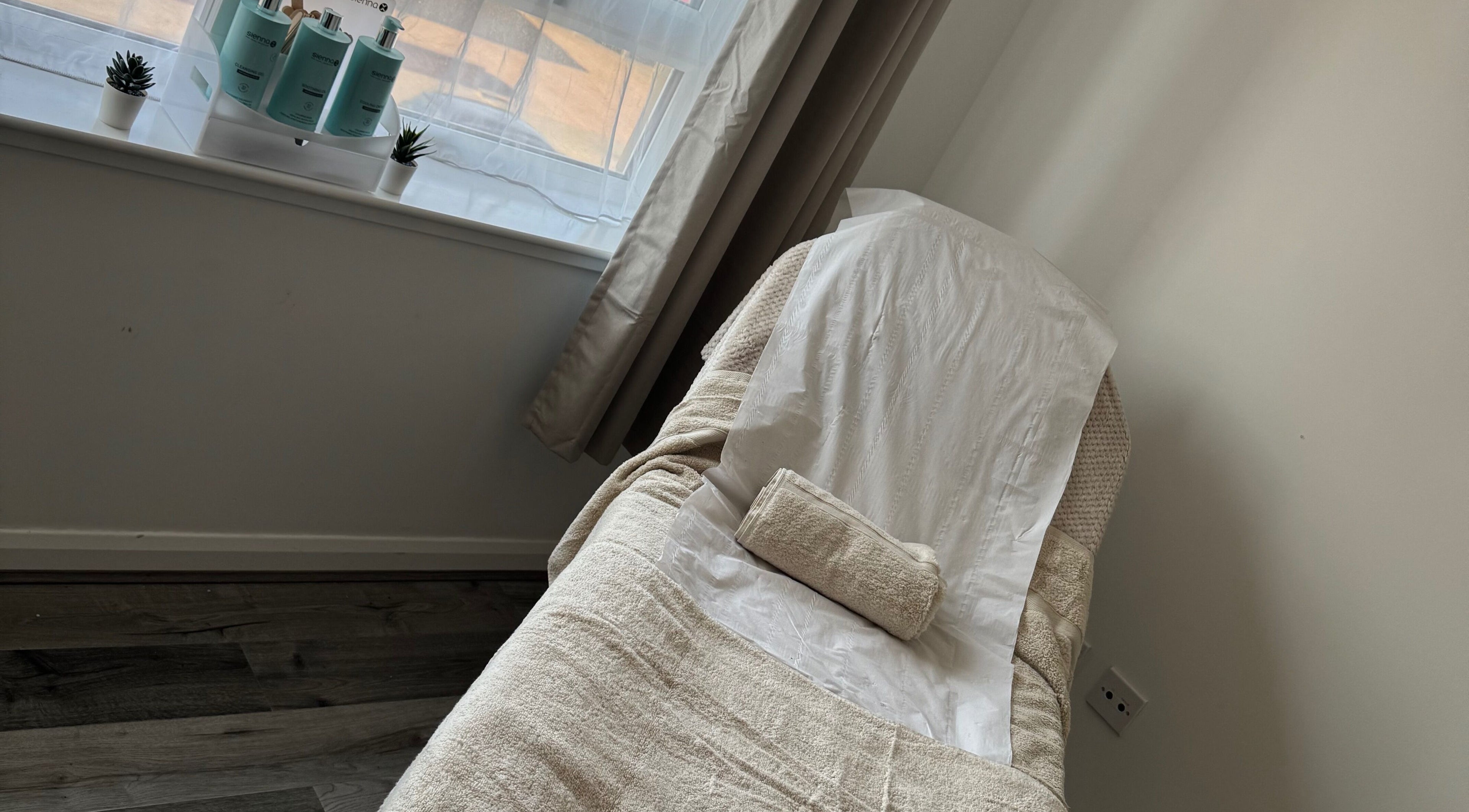 Relaxation room at Tame, Motherwell, Scotland, GB with a comfy massage table and skincare products.