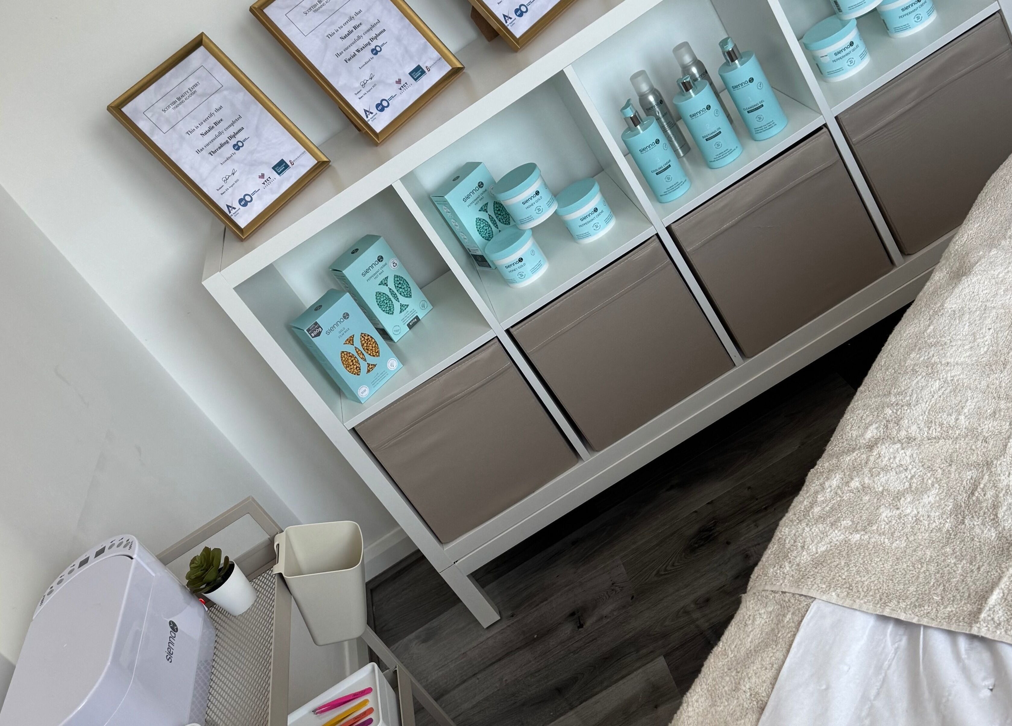 Tame relaxation room in Motherwell, Scotland, GB with skincare products and a treatment bed.