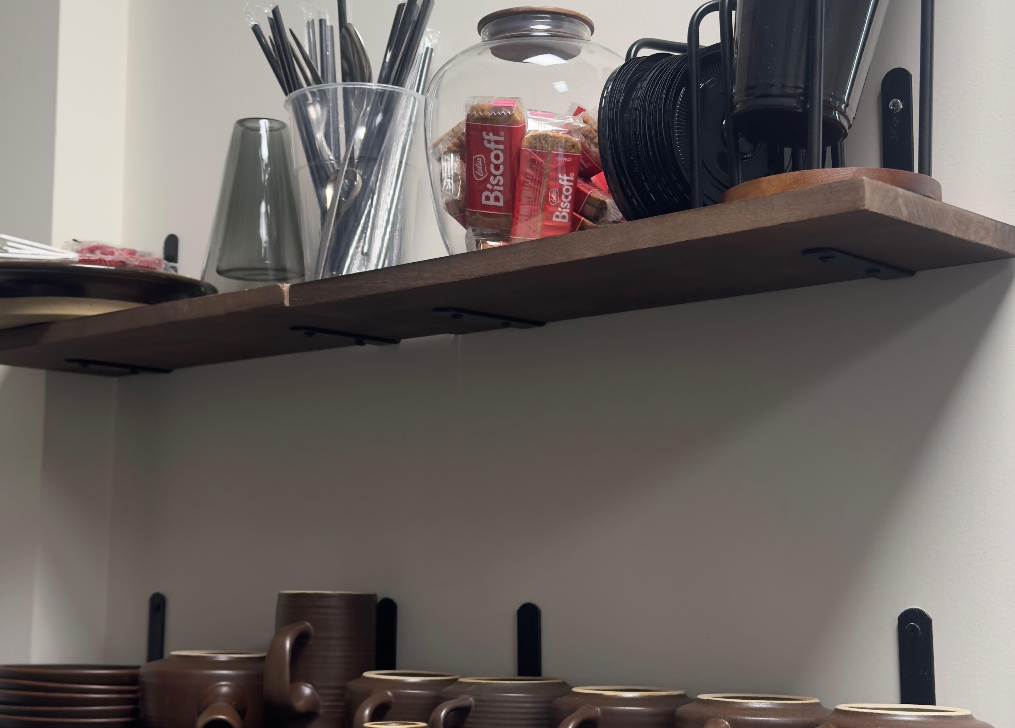 Tea and snack shelf at TheBeautyVine, Birmingham, England, GB, featuring cups, biscuits, and straws.
