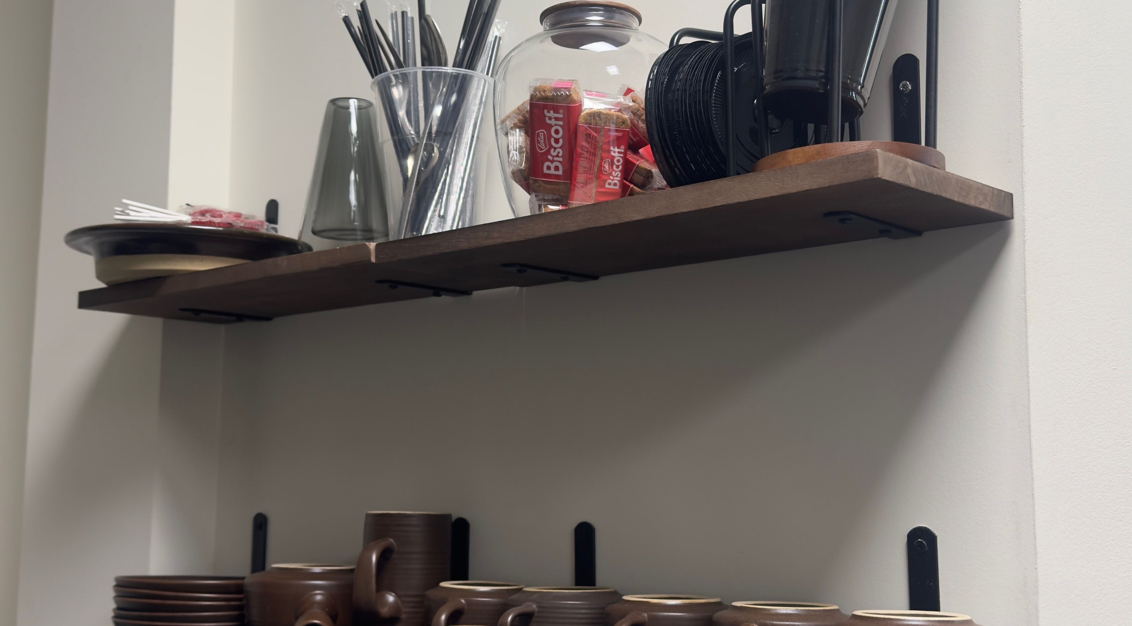 Tea and snack shelf at TheBeautyVine, Birmingham, England, GB, featuring cups, biscuits, and straws.
