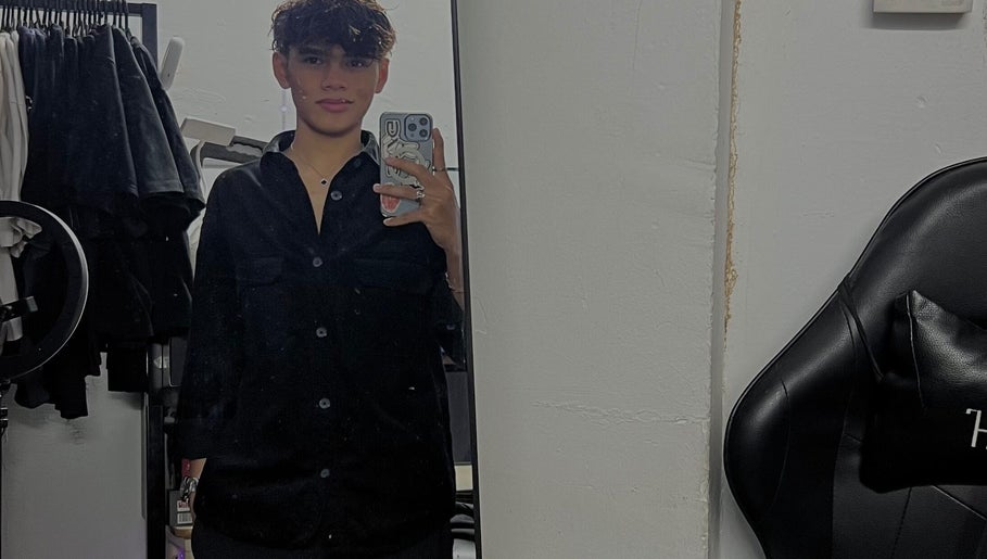 A stylish person taking a mirror selfie at zack.haircuts in Klang, Selangor, MY, with modern salon background.