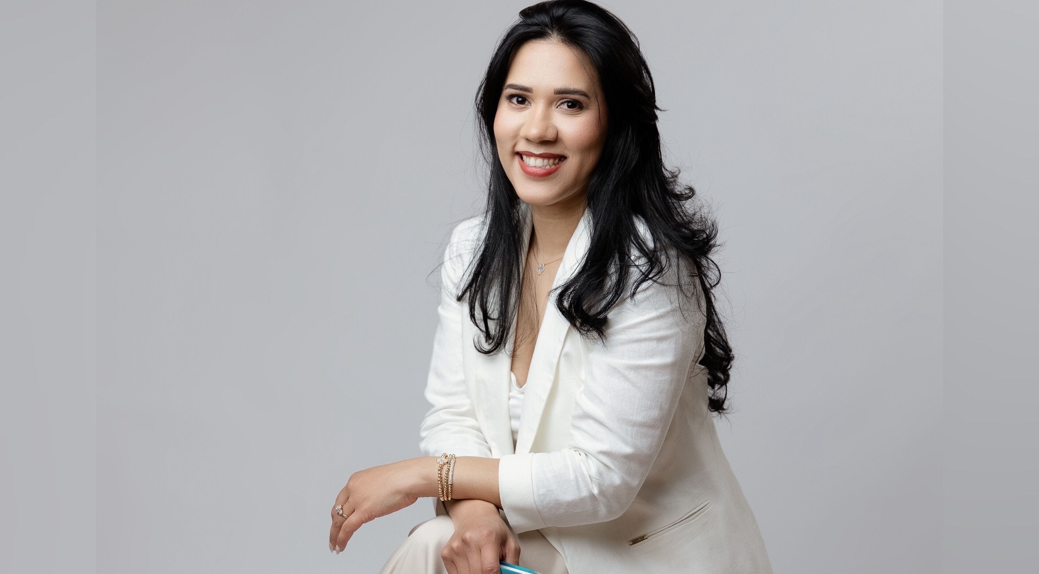 Professional woman in white suit at Karine Chimenes Aesthetics, Falmouth, Massachusetts, US, exuding confidence.