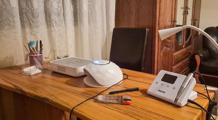 Mesa de manicure no Angélica Nails em Braga, Braga, PT, com ferramentas profissionais e lâmpada moderna.