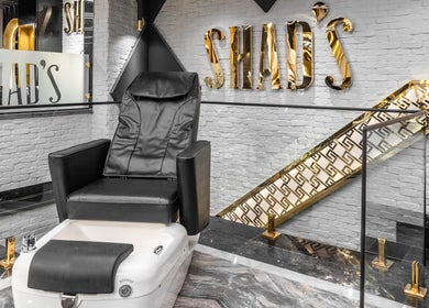 كراسي عصرية مذهبة في Shad's Men's Salon، القاهرة، EG، توفر تجربة فاخرة واستجمام.