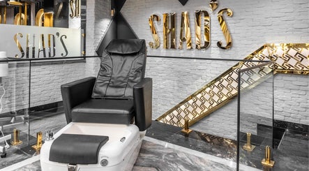 كراسي عصرية مذهبة في Shad's Men's Salon، القاهرة، EG، توفر تجربة فاخرة واستجمام.