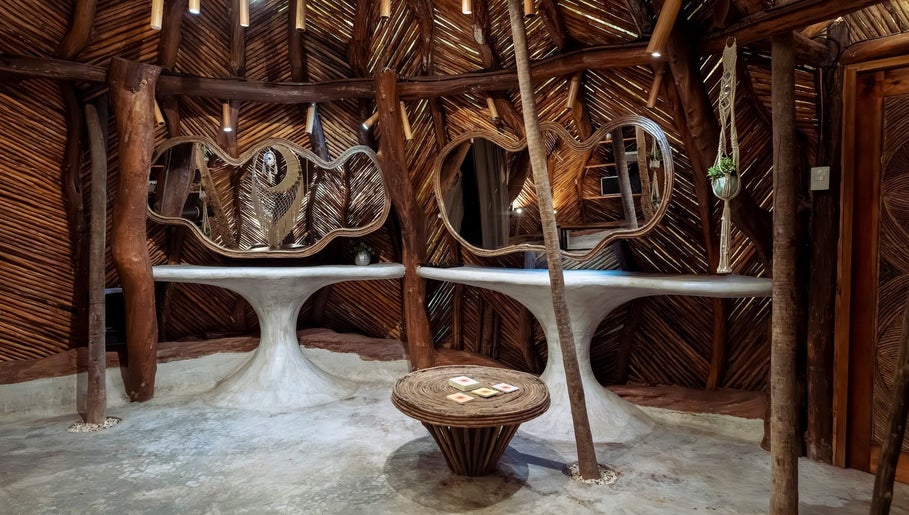 Interior rústico de Oceanik Balance en Tulum, Quintana Roo, MX con mesas y espejos únicos.