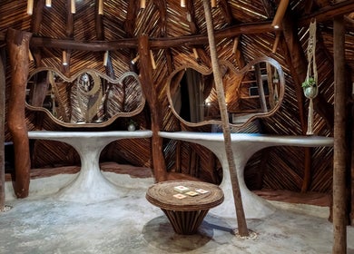 Interior rústico de Oceanik Balance en Tulum, Quintana Roo, MX con mesas y espejos únicos.
