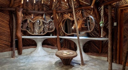 Interior rústico de Oceanik Balance en Tulum, Quintana Roo, MX con mesas y espejos únicos.