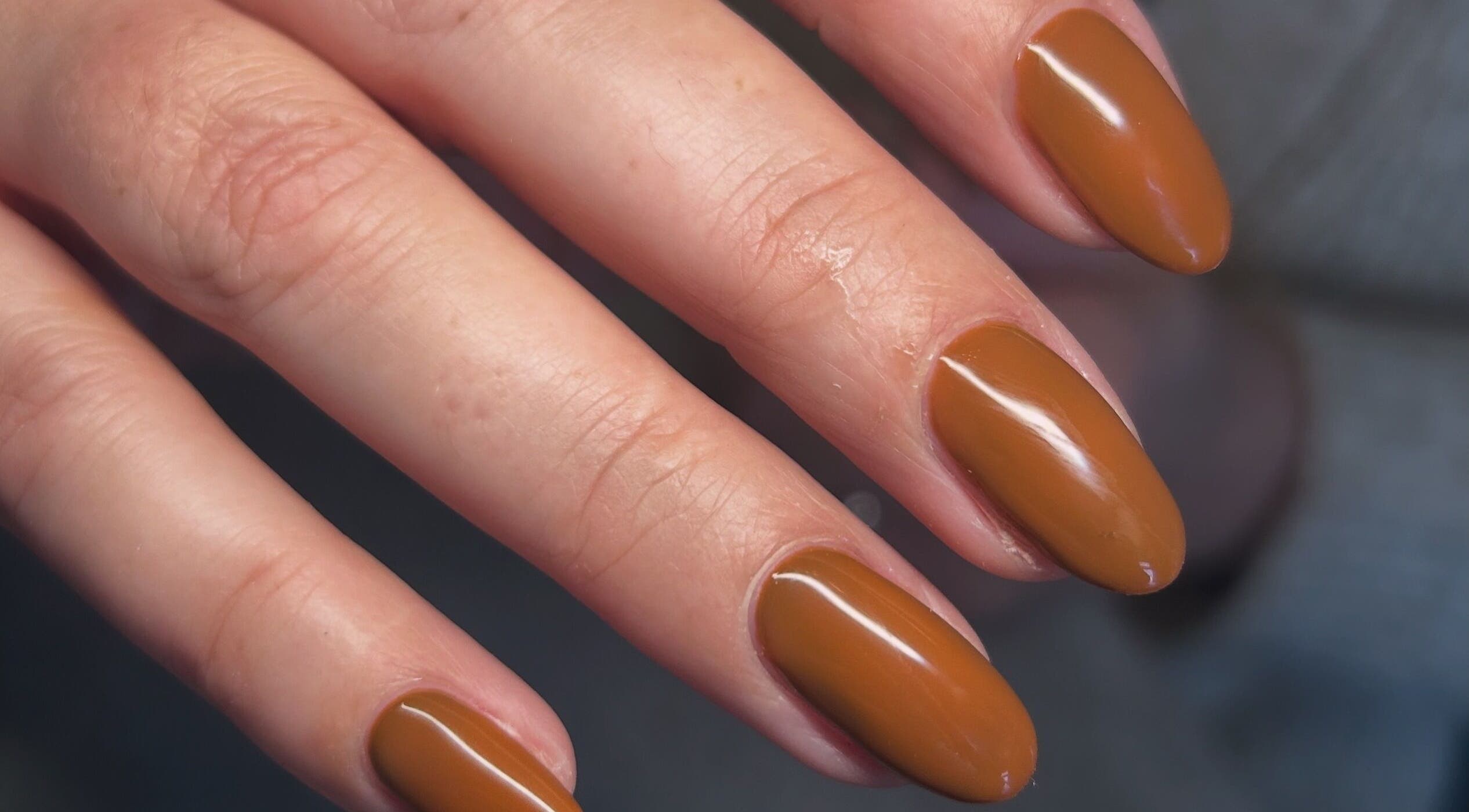 Elegant bronze manicure at Femme Lounge, South Lanarkshire, Scotland, GB, showcasing glossy nail art.