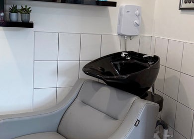 Modern hair wash station at Emilia Grace Hair, Birmingham, England, GB with sleek black basin and gray chair.