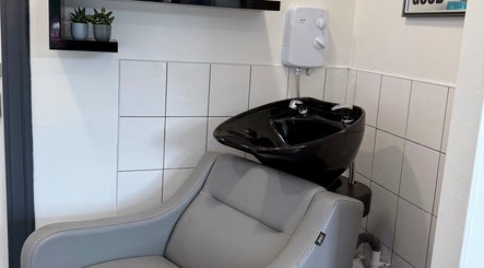 Modern hair wash station at Emilia Grace Hair, Birmingham, England, GB with sleek black basin and gray chair.