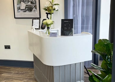 Reception desk at Emilia Grace Hair, Birmingham, England, GB with elegant decor and vibrant plants.
