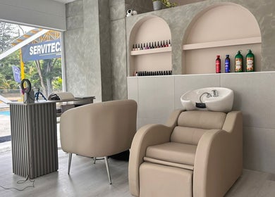 Interior moderno de RADIAN BARBER Y SALÓN en Cali, Valle Del Cauca, CO con sillas cómodas y estantería elegante.