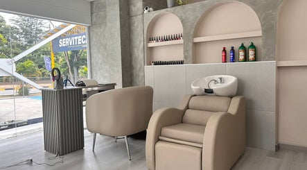 Interior moderno de RADIAN BARBER Y SALÓN en Cali, Valle Del Cauca, CO con sillas cómodas y estantería elegante.