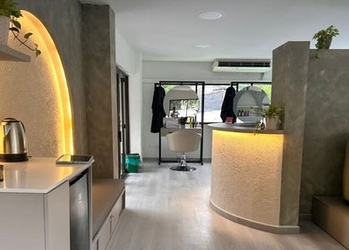 Interior elegante de RADIAN BARBER Y SALÓN en Cali, Valle Del Cauca, CO, mostrando silla de estilista e iluminación cálida.
